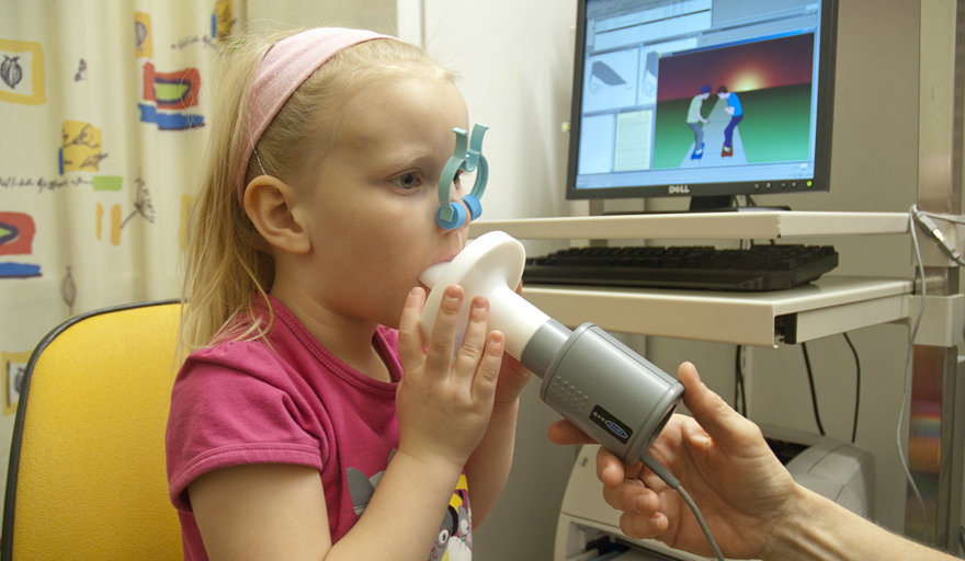 Ett barn blåser i en spirometer