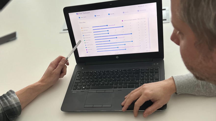 Två personer tittar på datorskärm där systemet Dialog+ visas